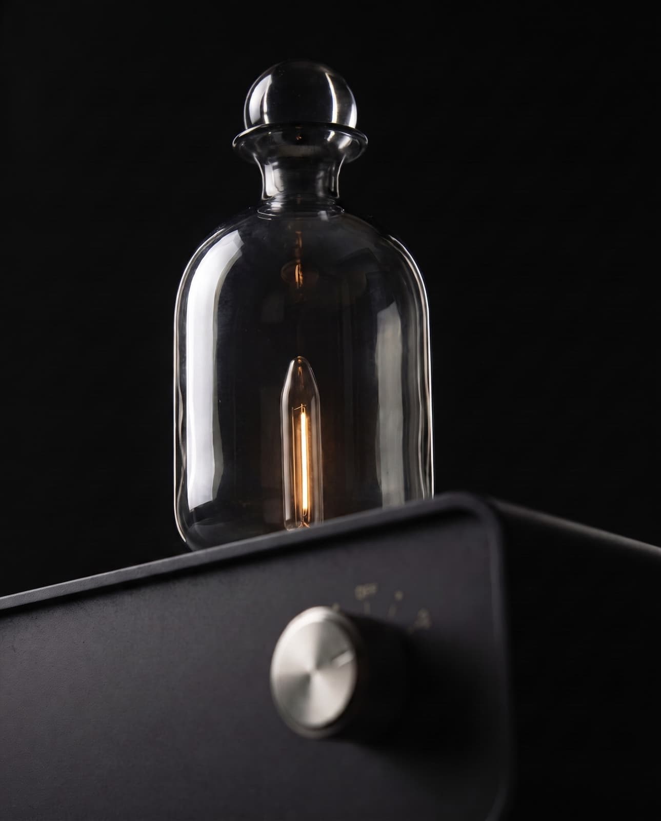 The smoked glass vessel of The Still, lit softly from within